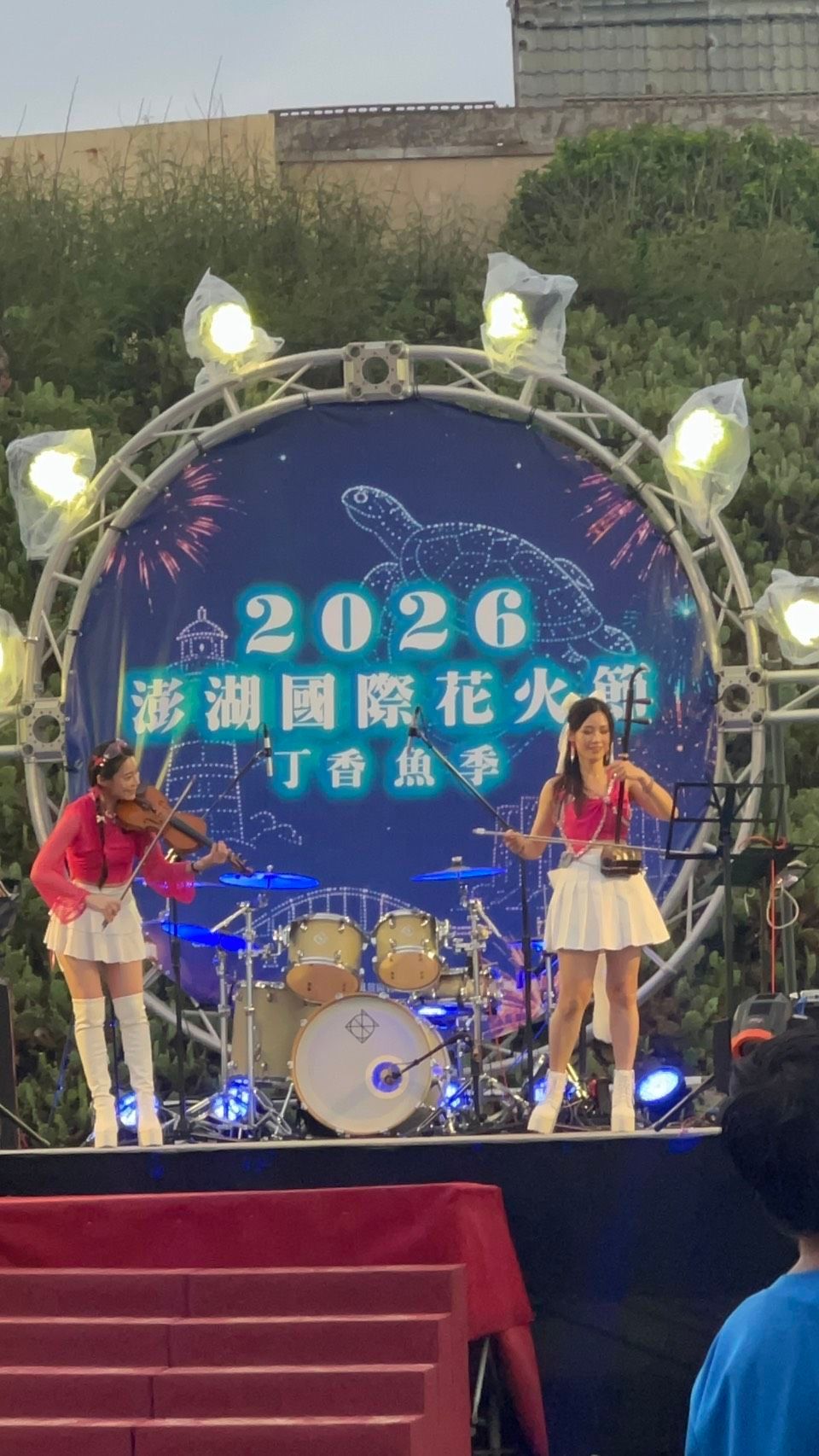 胡琴姐姐與小提琴手在 2026 澎湖國際花火節舞台上合奏，後方為鼓組